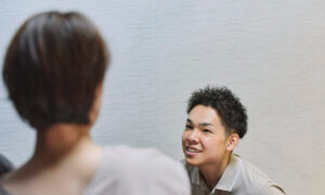 企業訪問し、院長が女性従業員の身体の悩みを柔らかな表情で聞いている写真